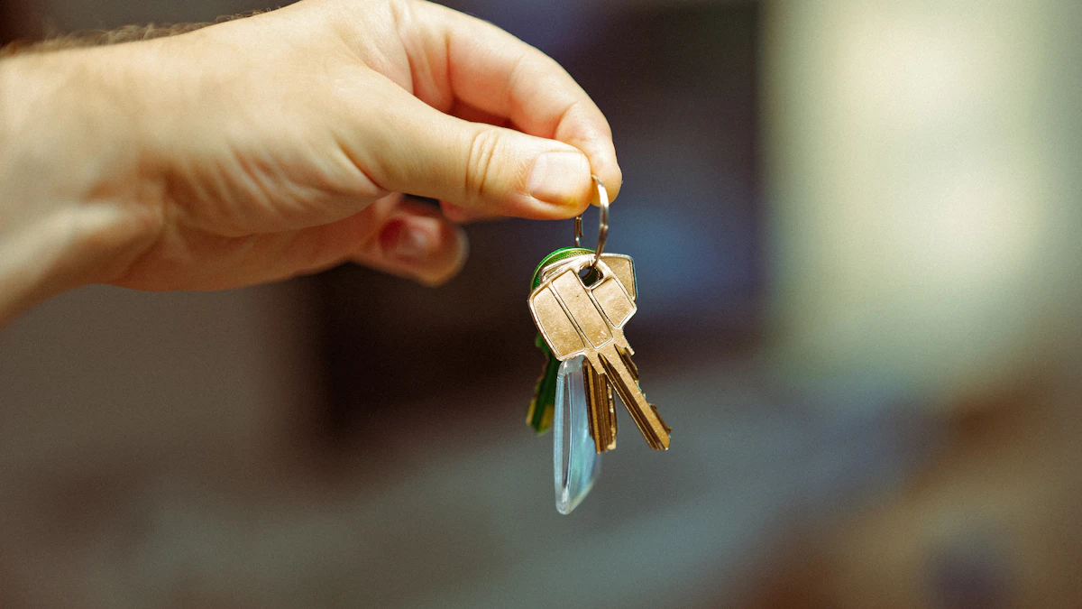 A hand holding up a small bunch of brass keys on a ring, with a blurred room behind
